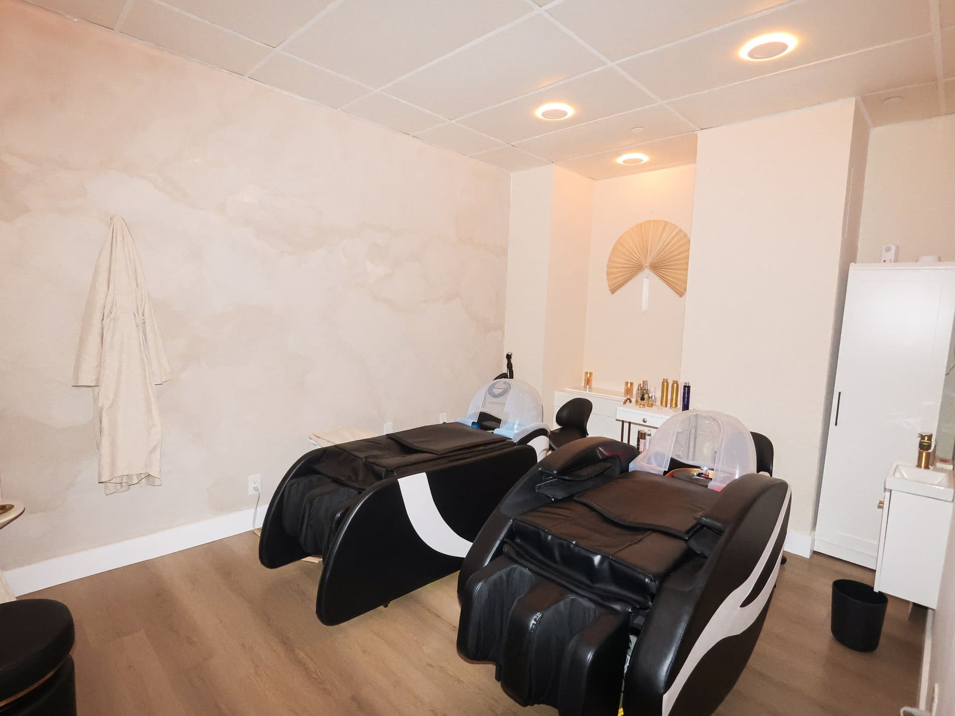 Head spa room with two reclining chairs and a hanging robe at Skin House of Beauty