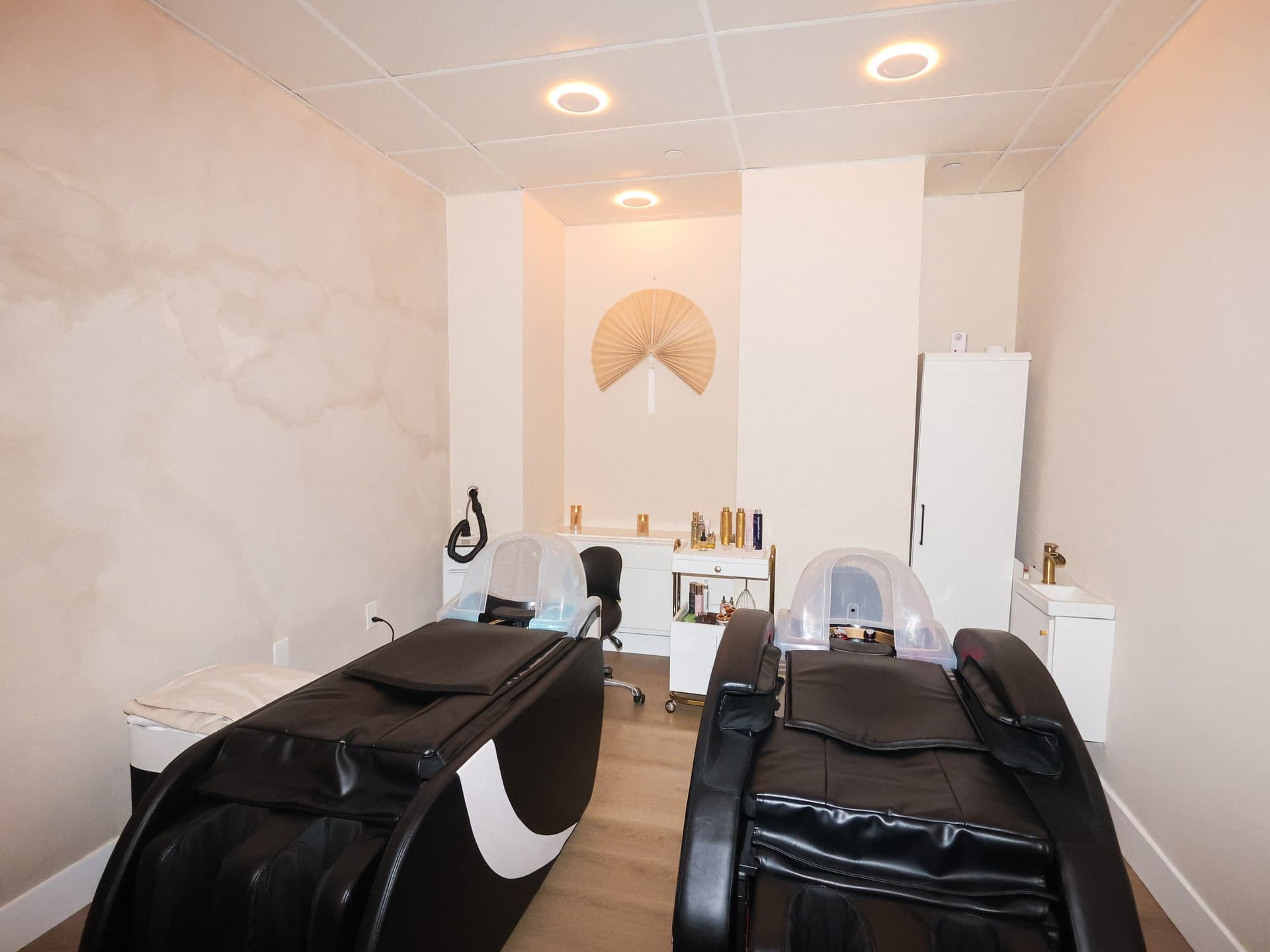 Head spa chairs beneath a fan wall sculpture at Skin House of Beauty