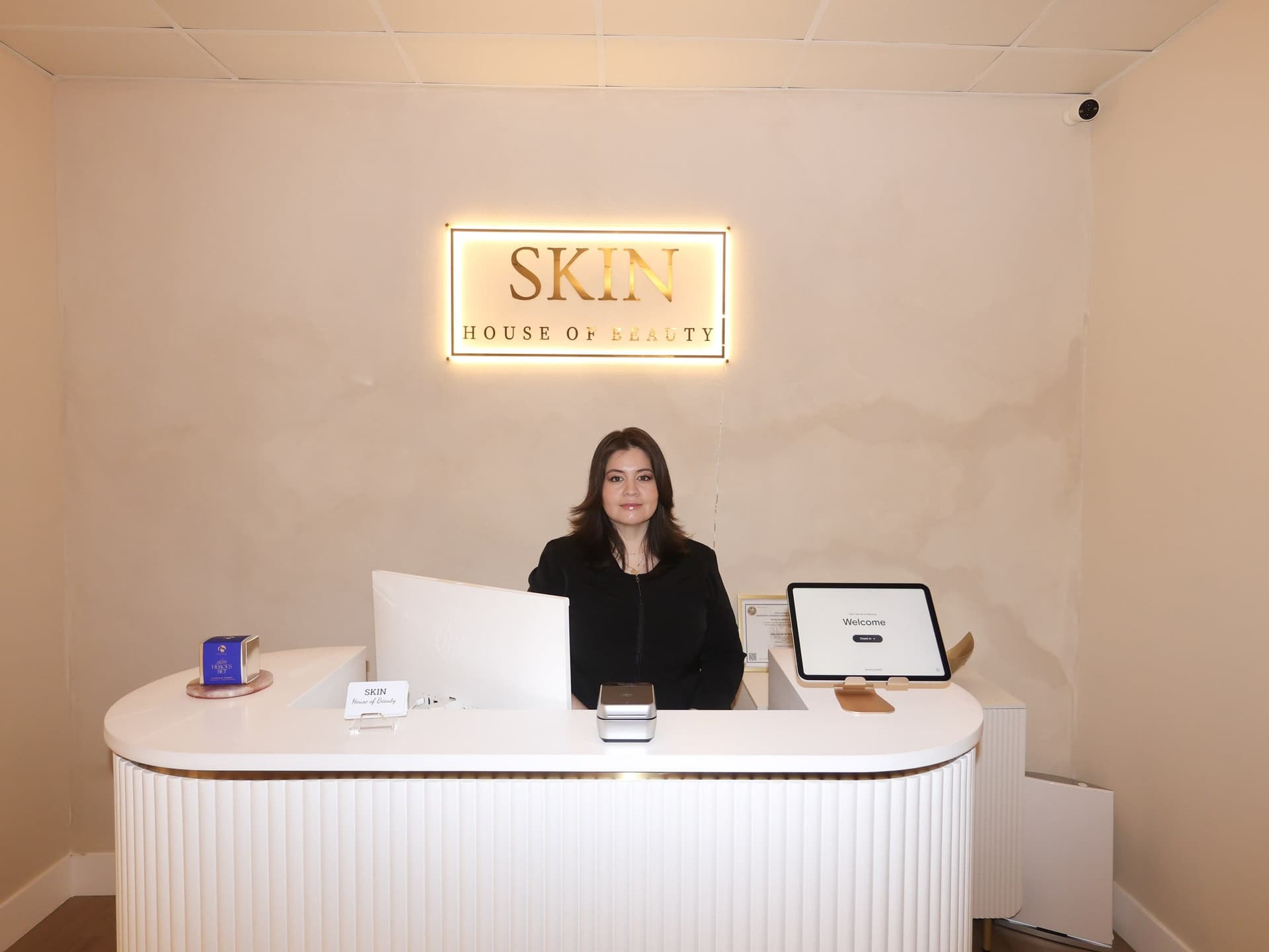 Reception desk beneath the illuminated Skin House of Beauty sign
