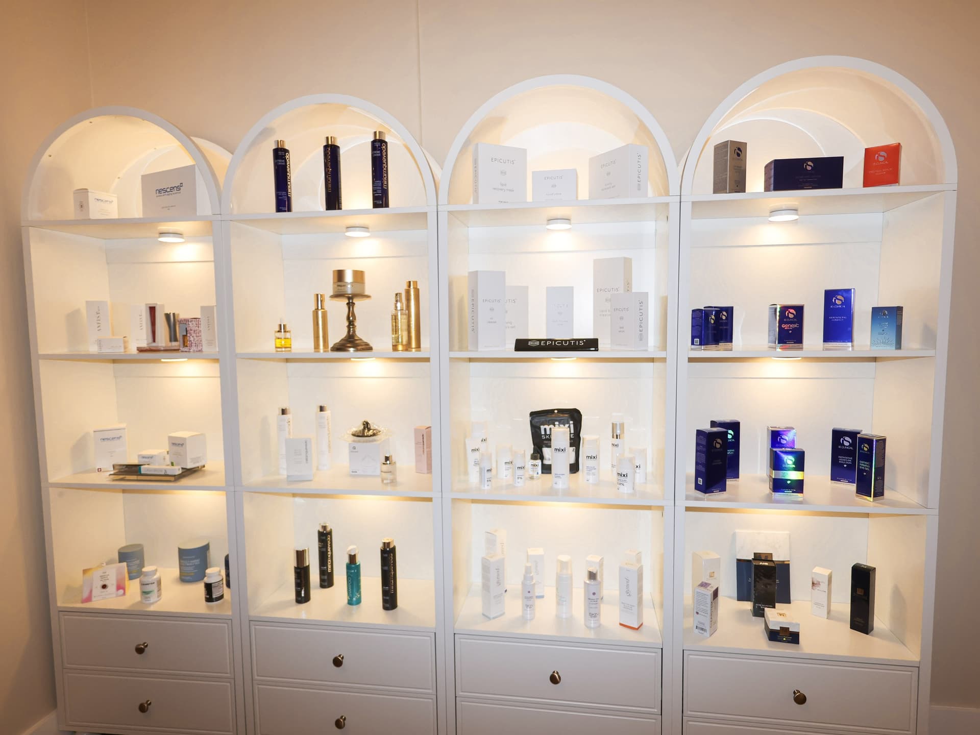 Backlit arched shelves of skincare products at Skin House of Beauty