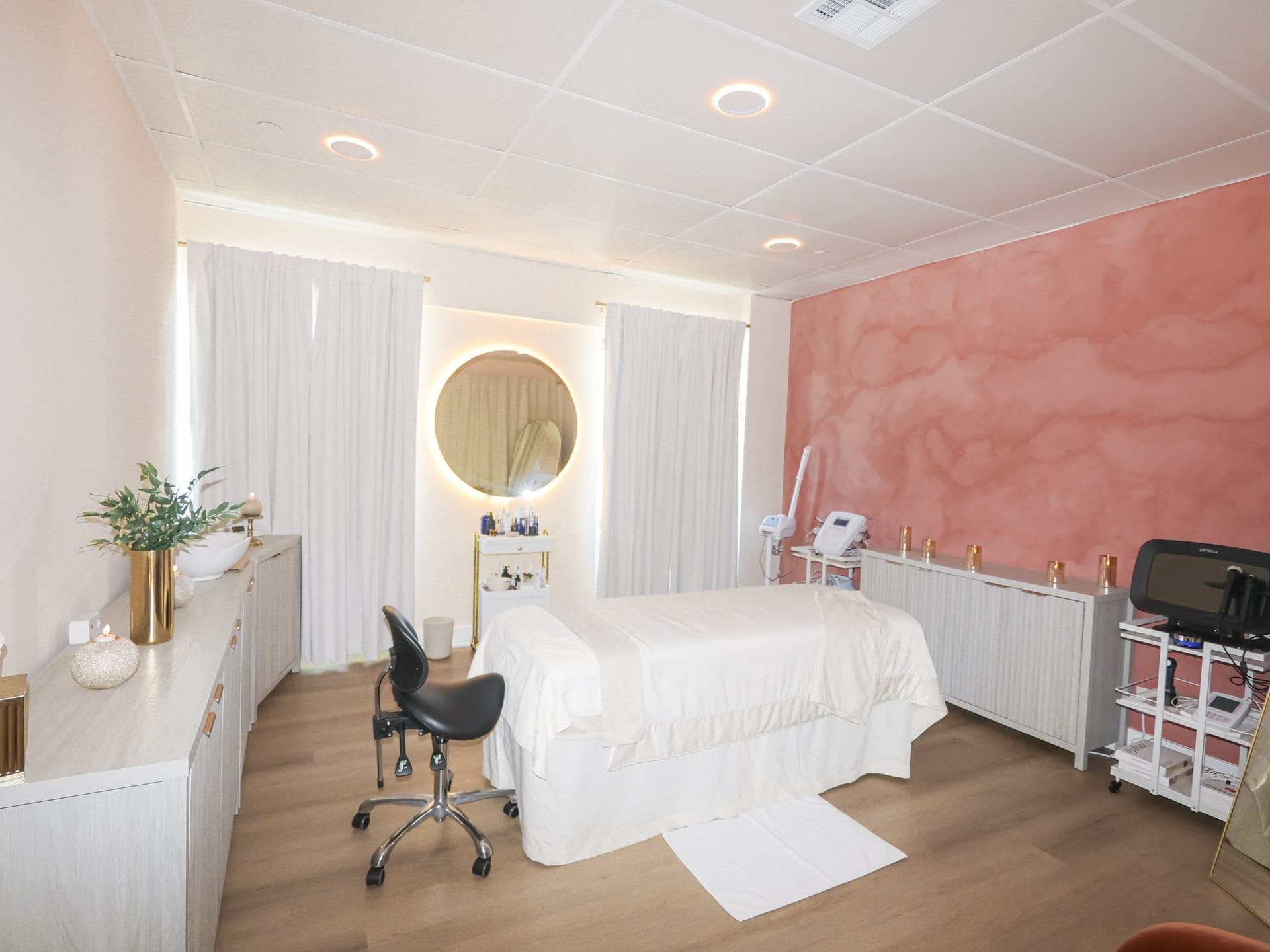 Treatment room with rose-plaster accent wall at Skin House of Beauty