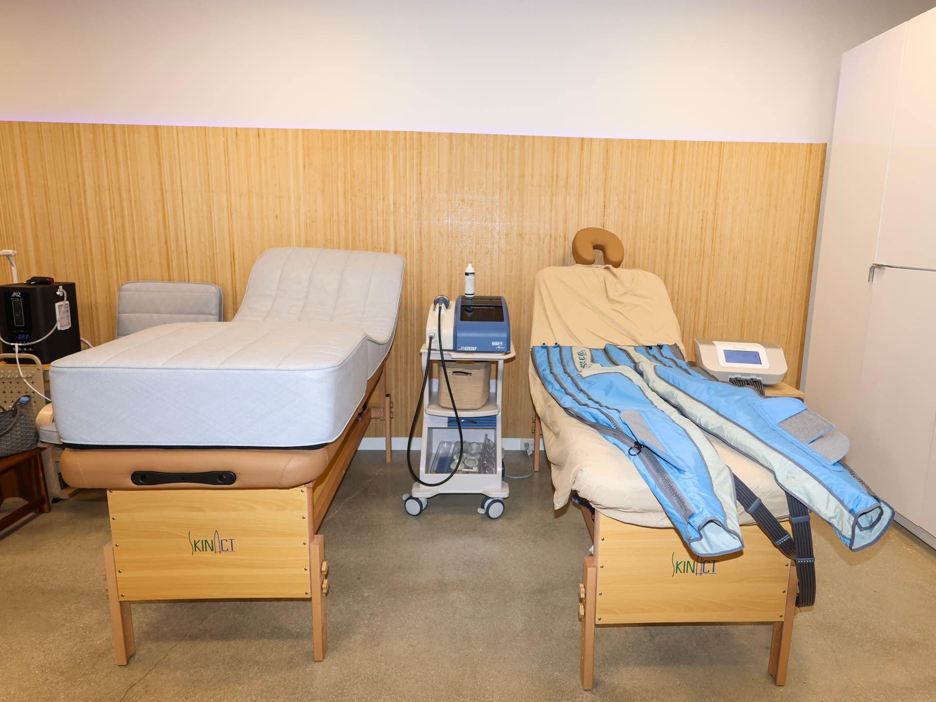 A recovery room at Evolve Longevity with two treatment beds and compression therapy boots.