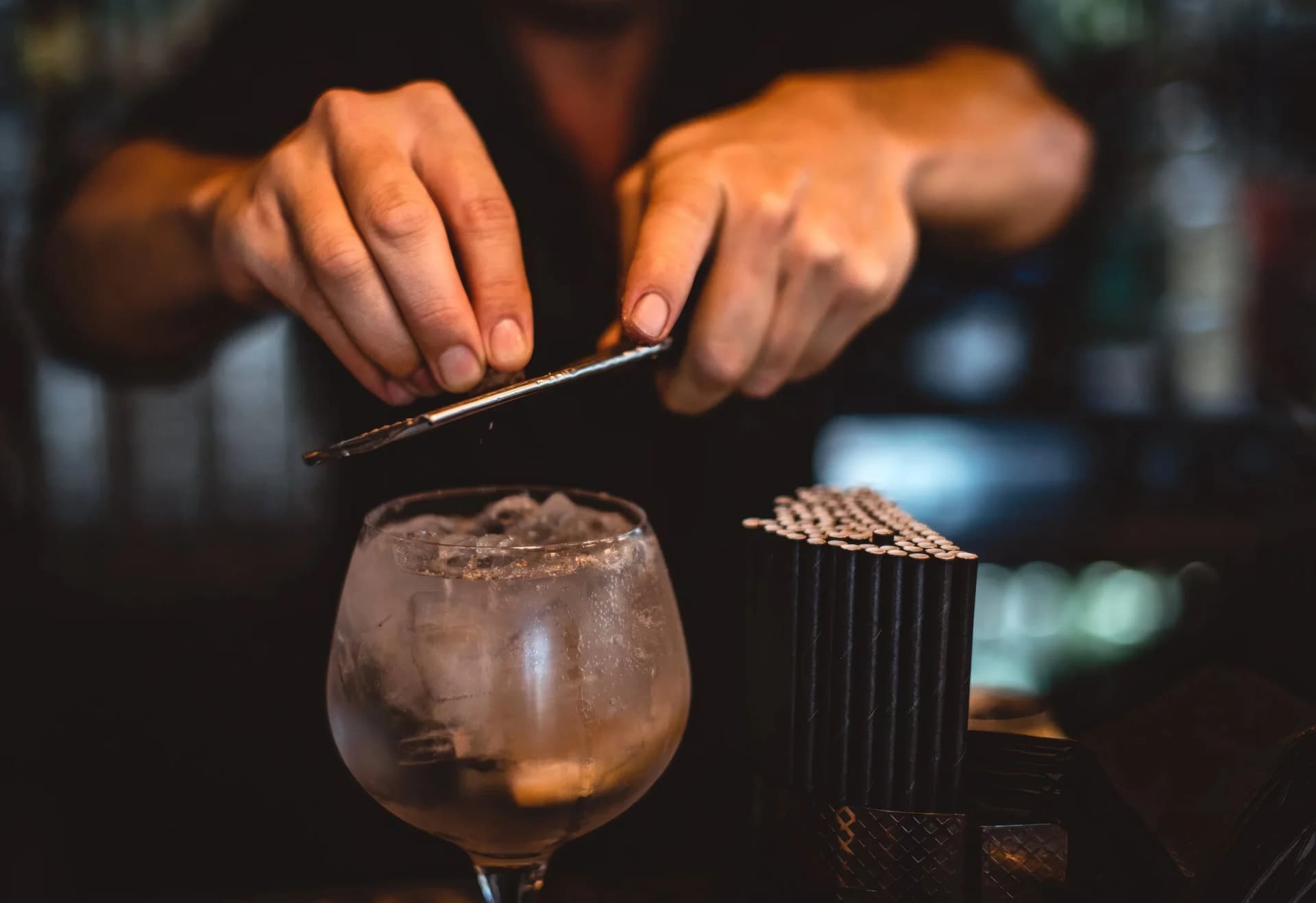 A bartender garnishes a Spanish-style gin and tonic at Barceloneta
