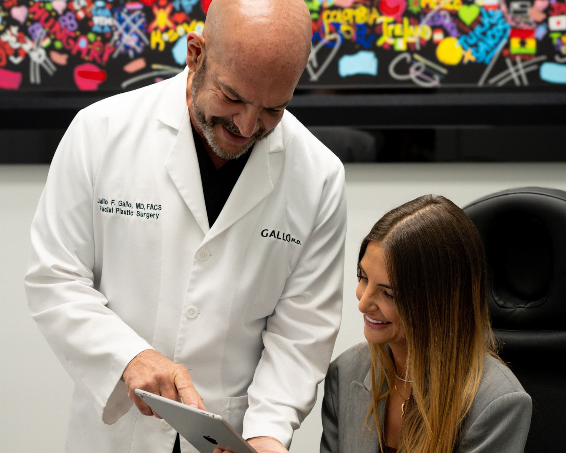 Dr. Julio Gallo reviews a tablet with a patient during a consultation at Gallo MD