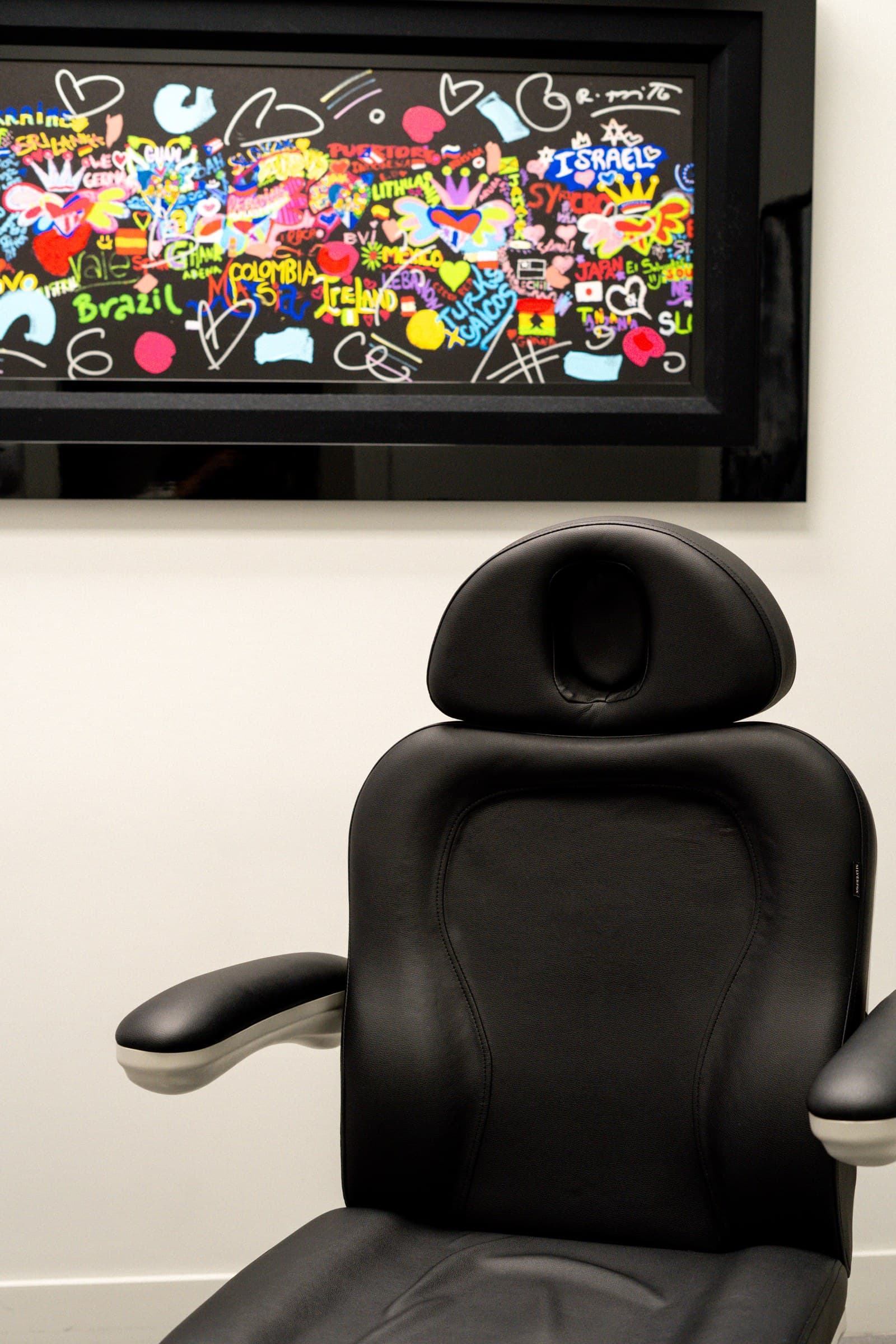 A treatment chair beneath colorful artwork at Gallo MD