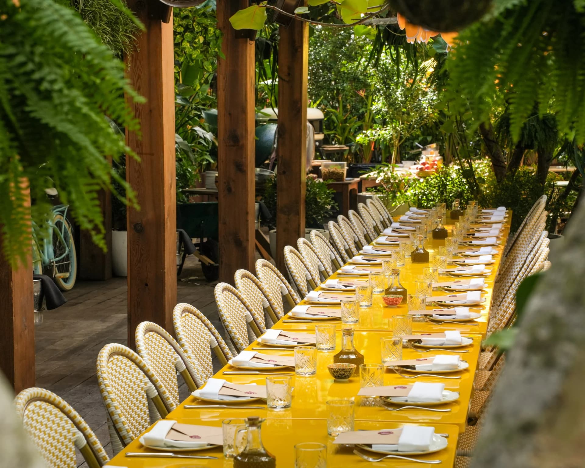 A long communal table set in the garden at Gardenia House in Miami Beach for TALES of a FEAST