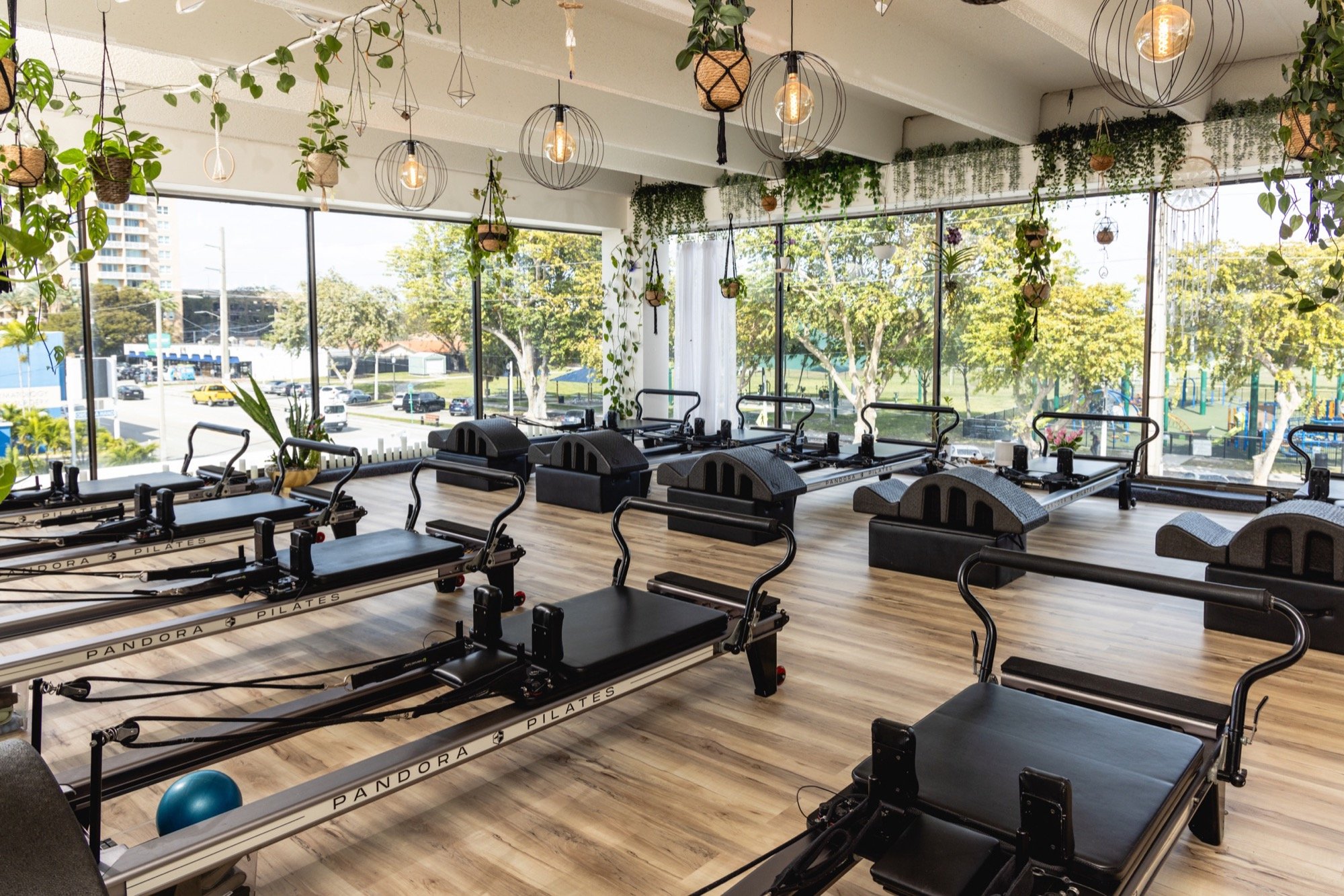 Pilates studio with reformers and hanging plants